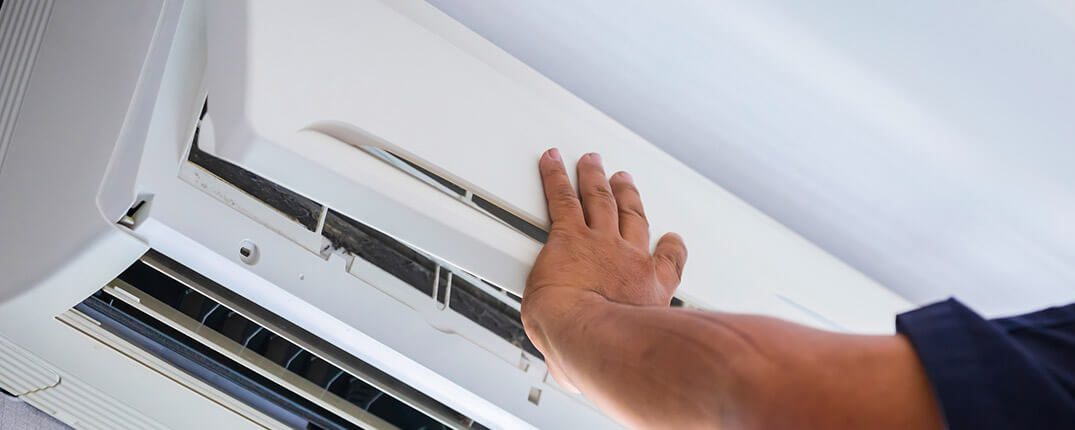 DunRite Heating & Air Inc. - Repairman fixing air conditioning system