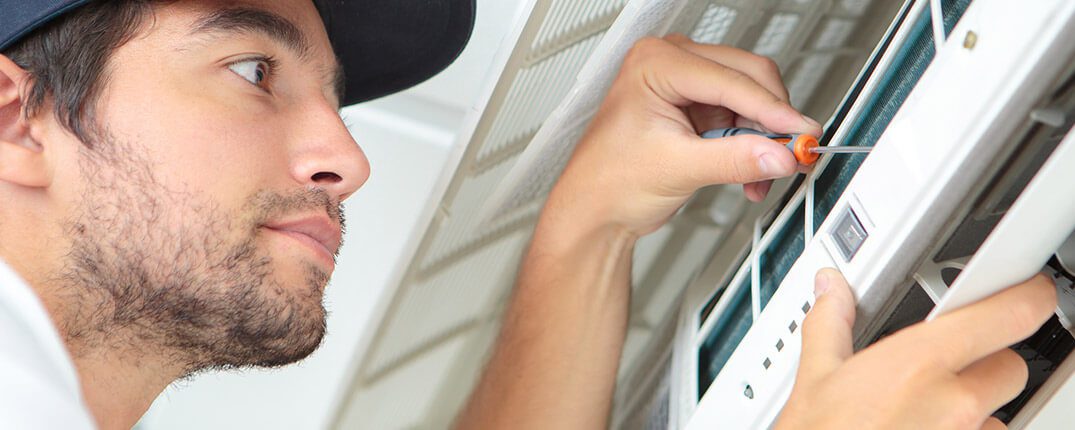 DunRite Heating & Air Inc. - Focused handyman testing air conditioning