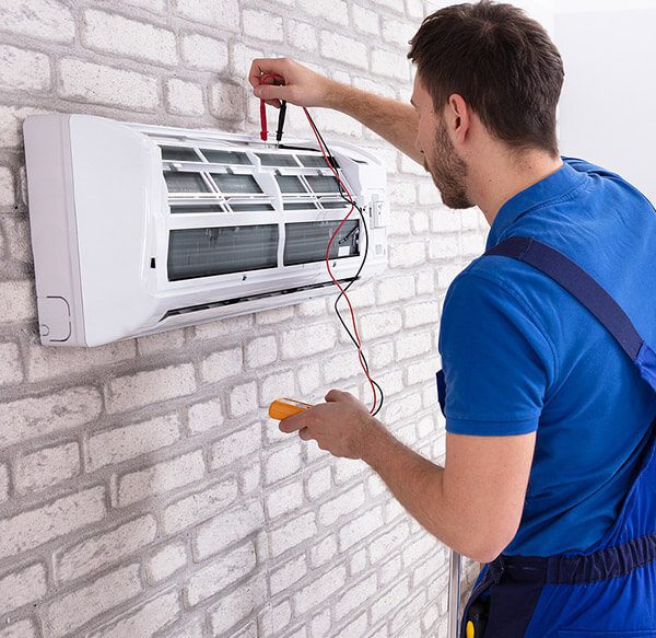 DunRite Heating & Air Inc. - Male Technician Repairing Air Conditioner With Digital Multimeter At Home