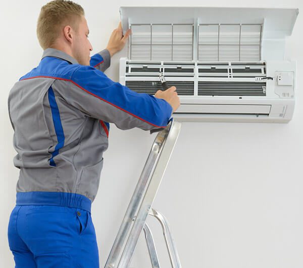 DunRite Heating & Air Inc. - technician repairing air conditioner