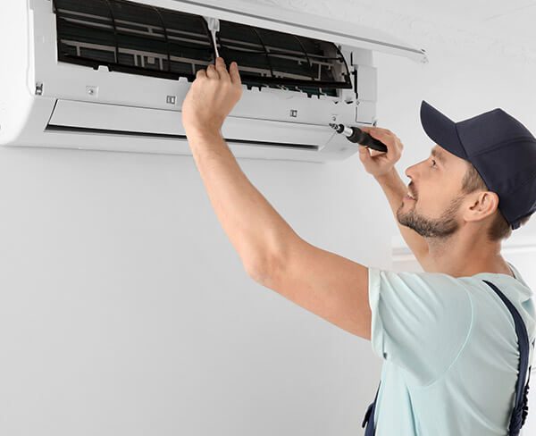 DunRite Heating & Air Inc. - technician repairing air conditioner